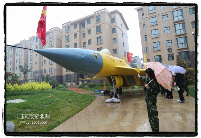 小區(qū)突然出現(xiàn)“飛機(jī)坦克”，其中殲15艦載戰(zhàn)斗機(jī)一架、99式主戰(zhàn)坦克一輛、武直-10武裝直升機(jī)一架，吸引了眾多市民雨中圍觀、合影。